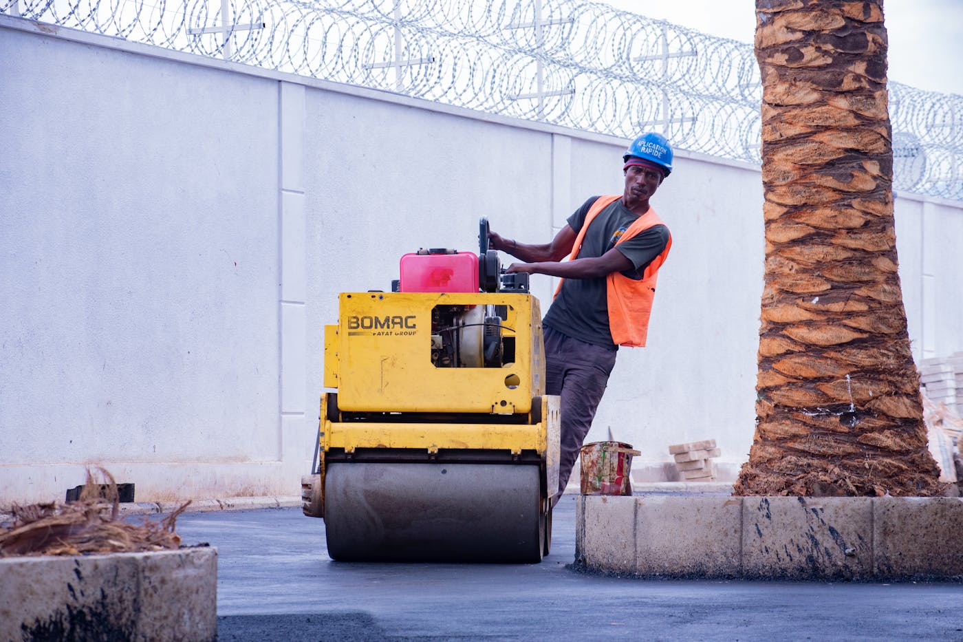 Contractor operating an asphalt roller while resurfacing a Perth driveway